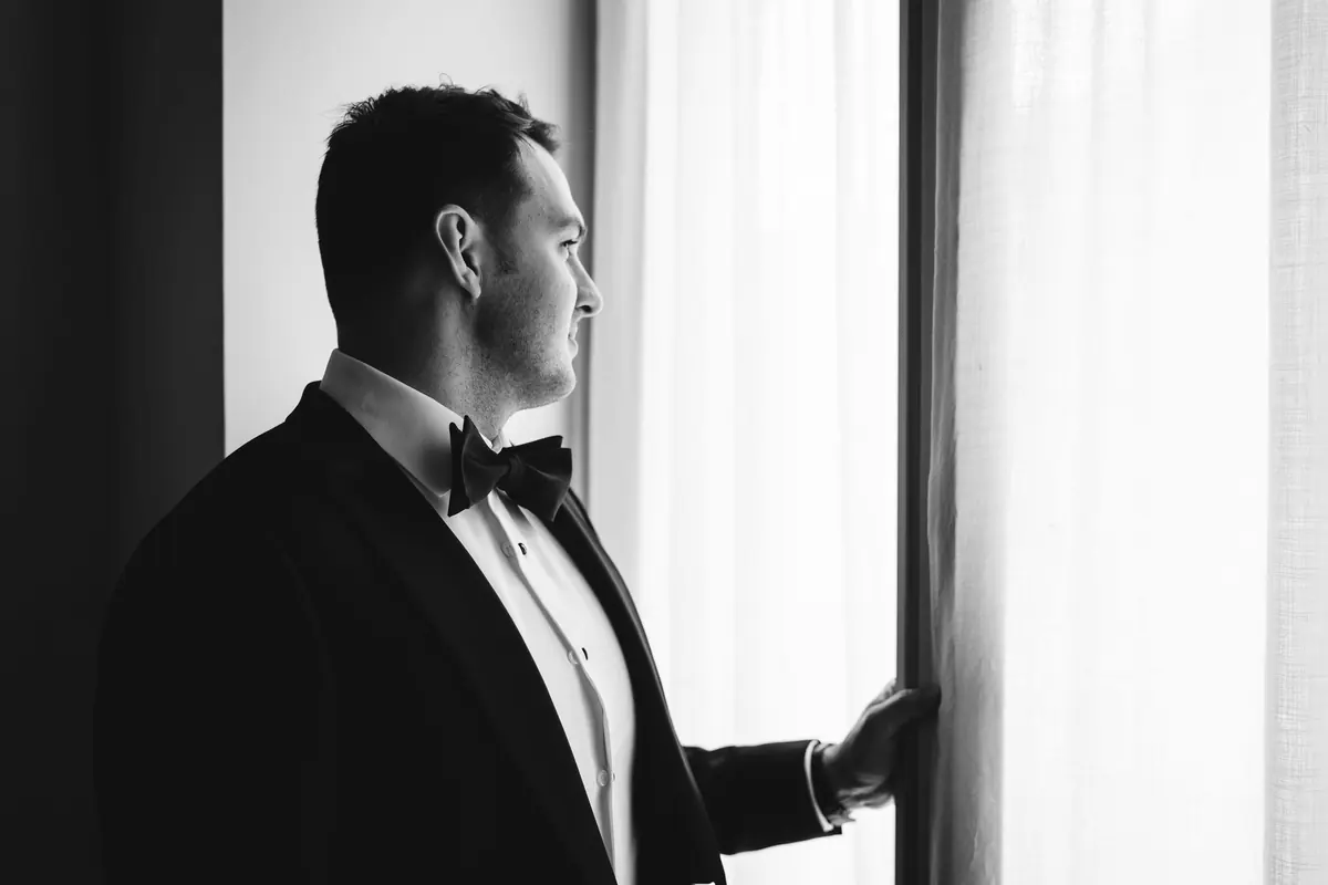 Drew in his tuxedo by the window, in black and white