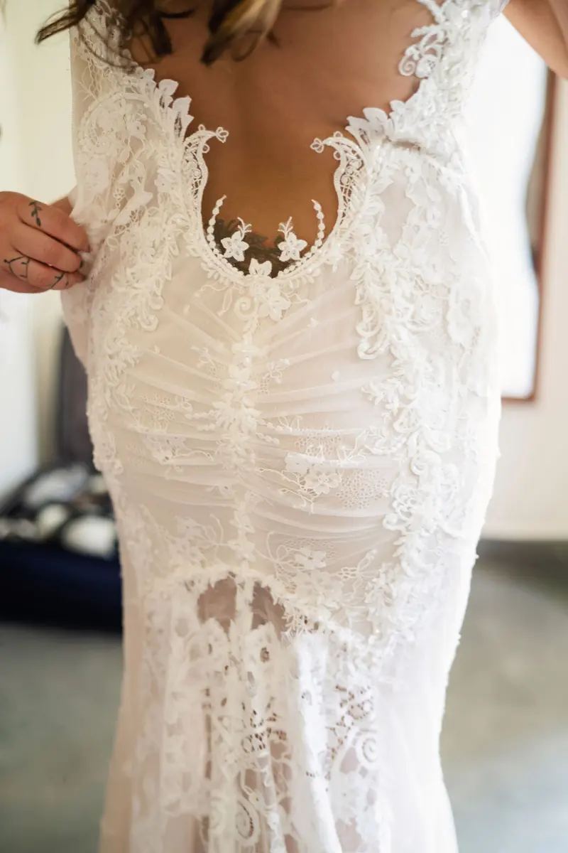 The lace back of Sara's Galia Lahav gown being fastened