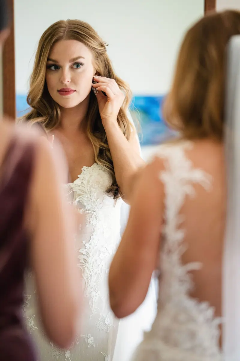 Bride smiling at her bridesmaid while getting ready