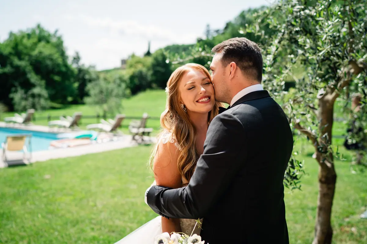 Sara kissing Drew on the cheek by the villa pool