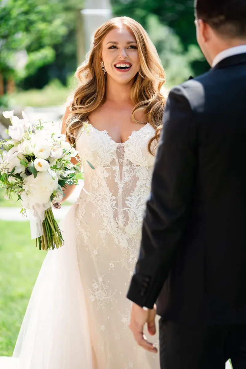 Bride laughing beside the groom on the lawn