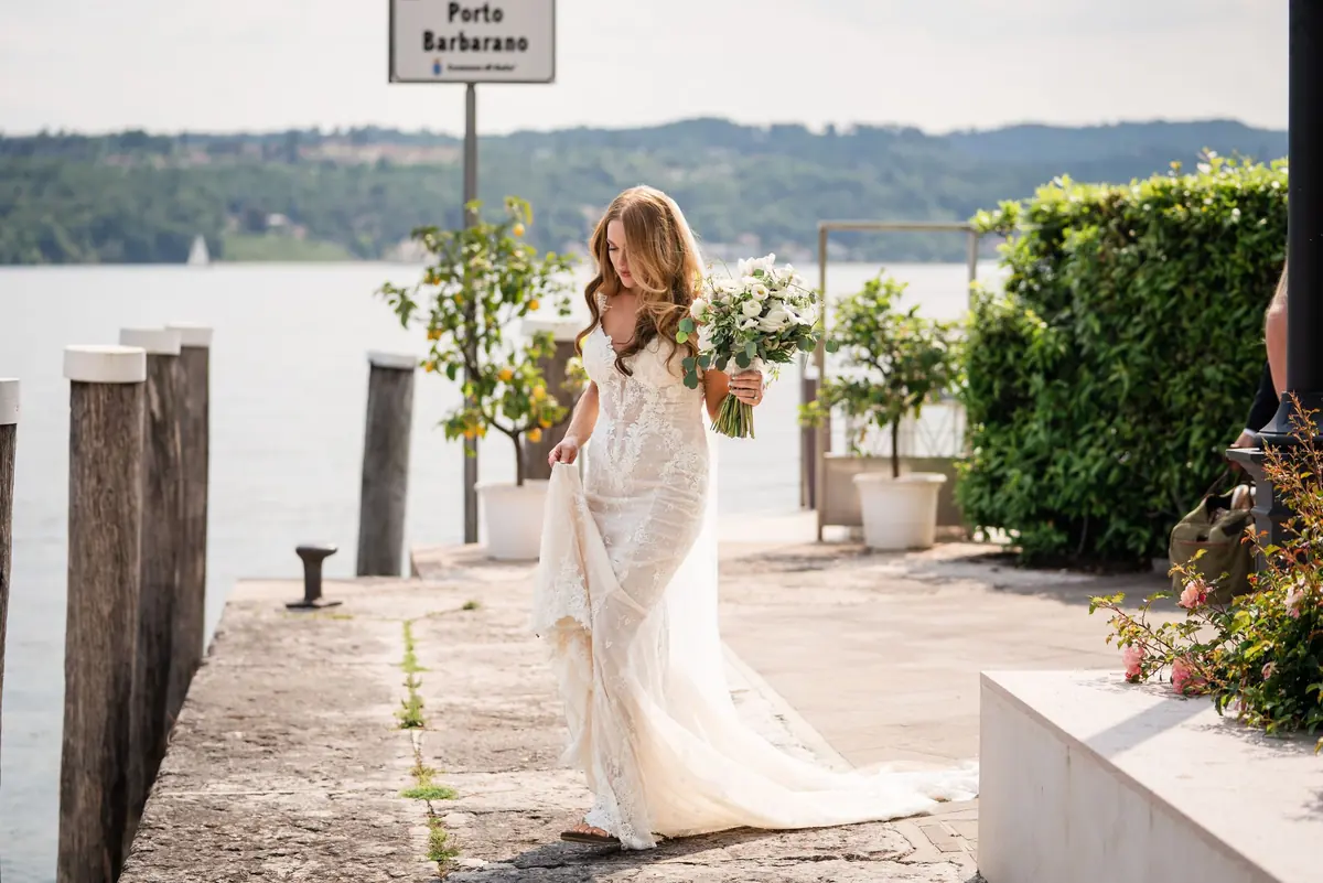 Sara in her gown walking along the jetty to the boat