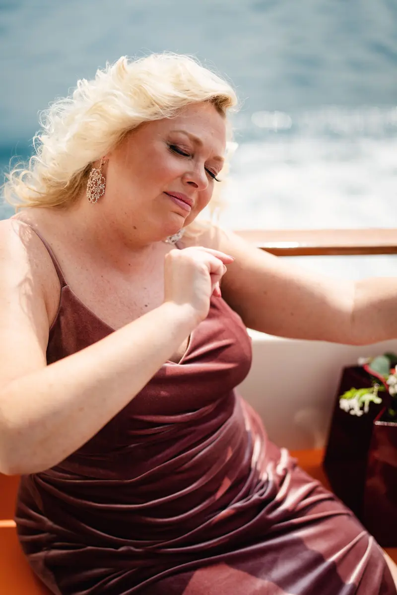 Bridesmaid with her eyes closed in the breeze on the boat