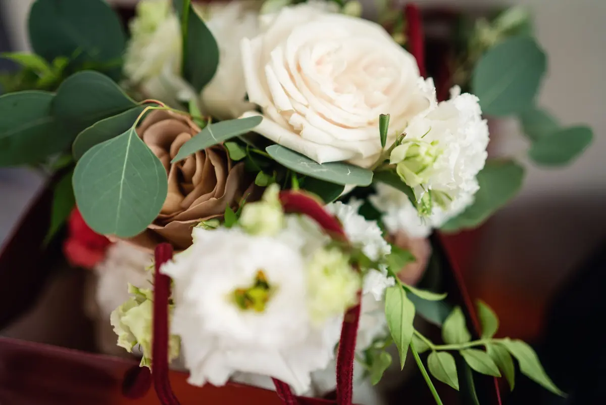 Sara's bouquet of white roses and eucalyptus on the boat seat