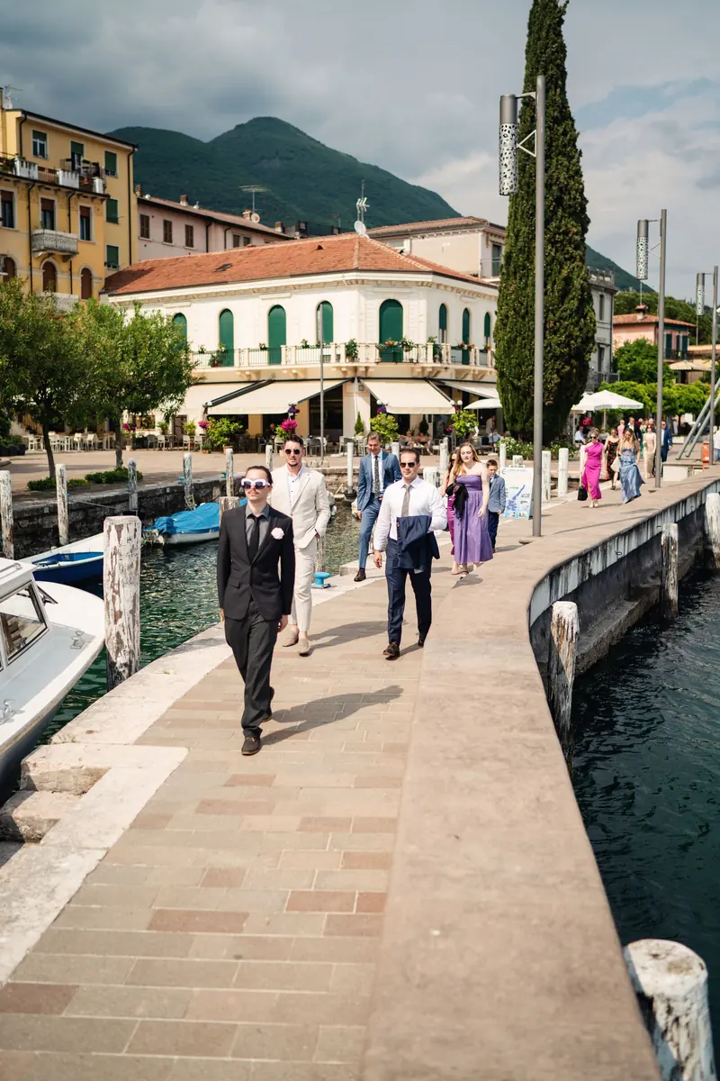 Guests walking down the jetty past the lakeside town to the boat