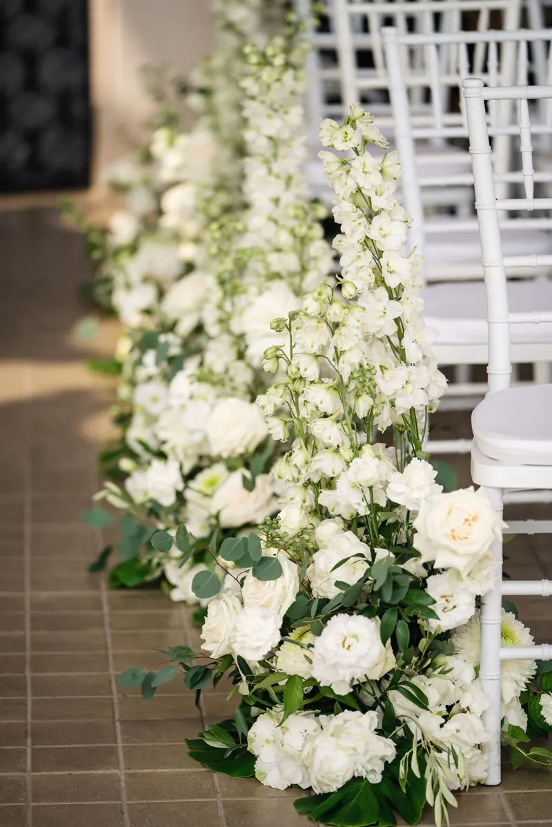 White flower arrangements lining the aisle for an Isola del Garda wedding ceremony