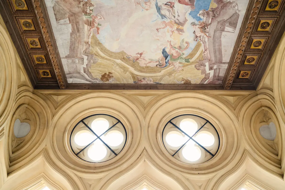 The frescoed ceiling and quatrefoil windows of the loggia