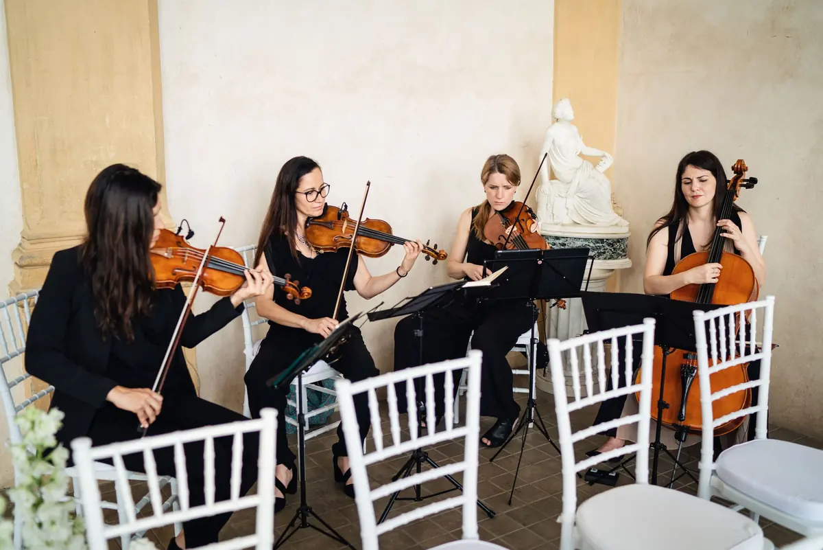 A string quartet playing among the ceremony chairs