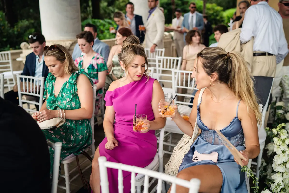 Guests with drinks waiting under the loggia for the ceremony