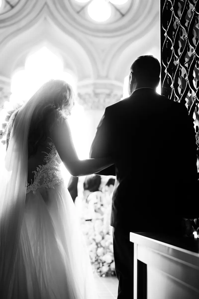 Black and white silhouette of the bride meeting the groom at the altar