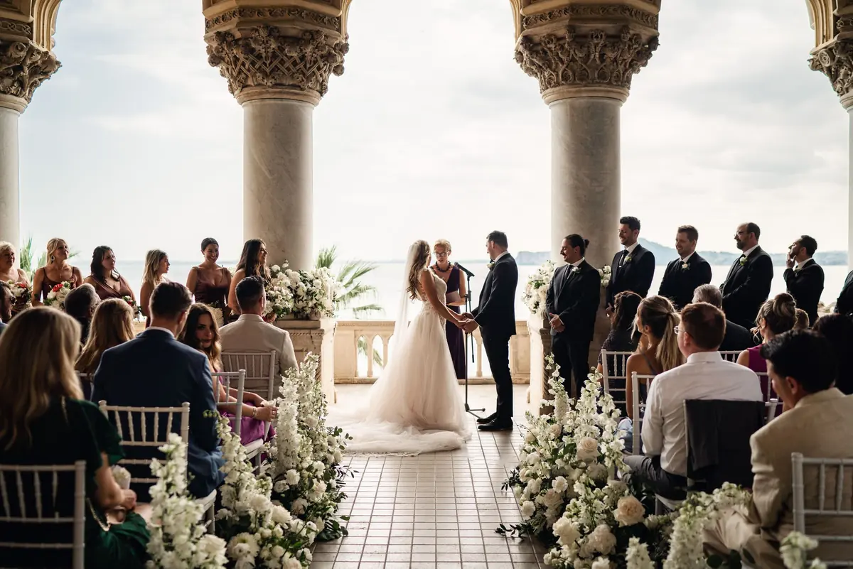 The ceremony under the loggia, with guests and white flowers