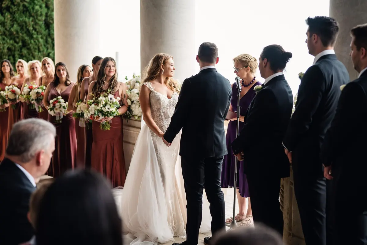 Bridesmaids and groomsmen standing beside Sara and Drew during the ceremony