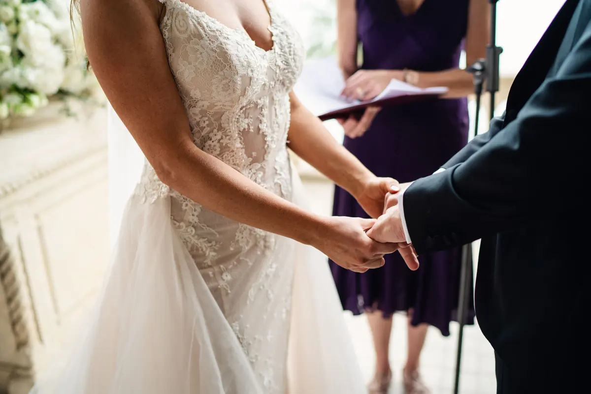 Close-up of Sara and Drew holding hands during the vows