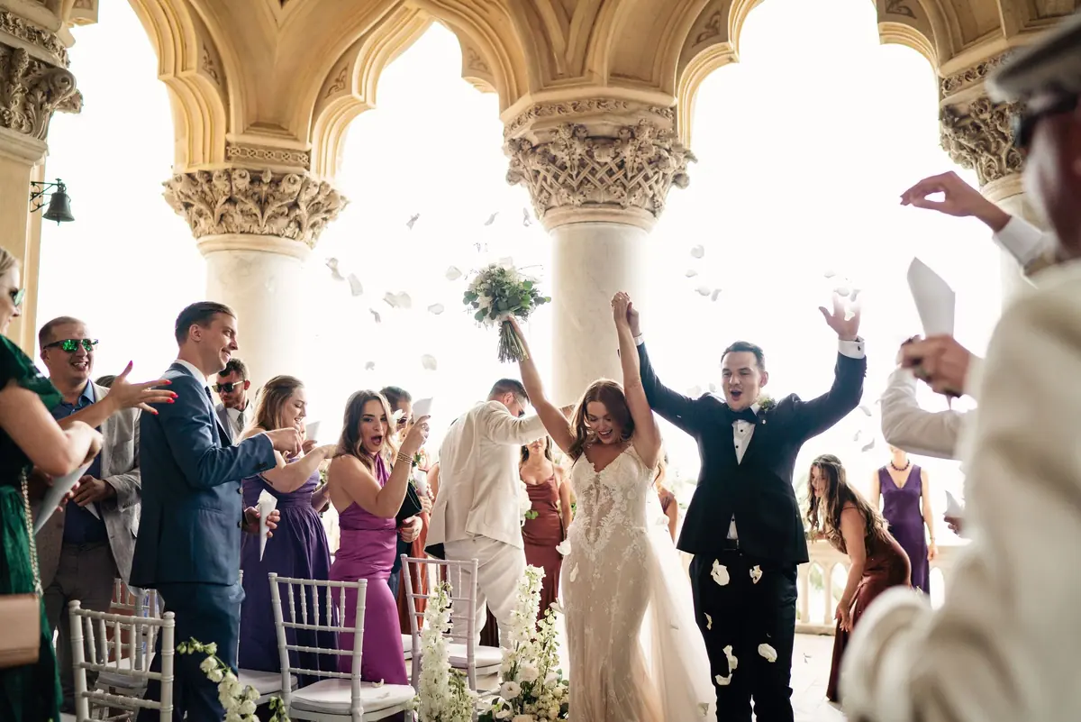 Sara and Drew walking back down the aisle as guests cheer