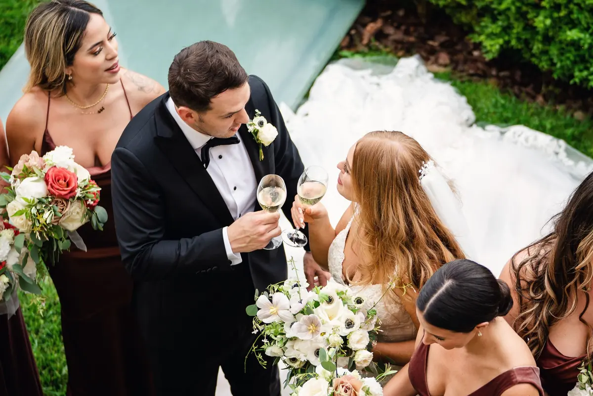 Drew with a glass of prosecco among the bridesmaids