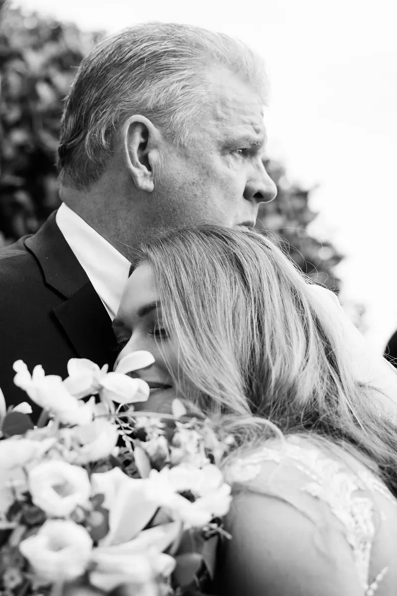 Sara's father holding her close, in black and white