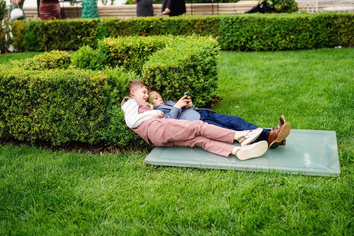 Two guests stretched out on the lawn by the hedges