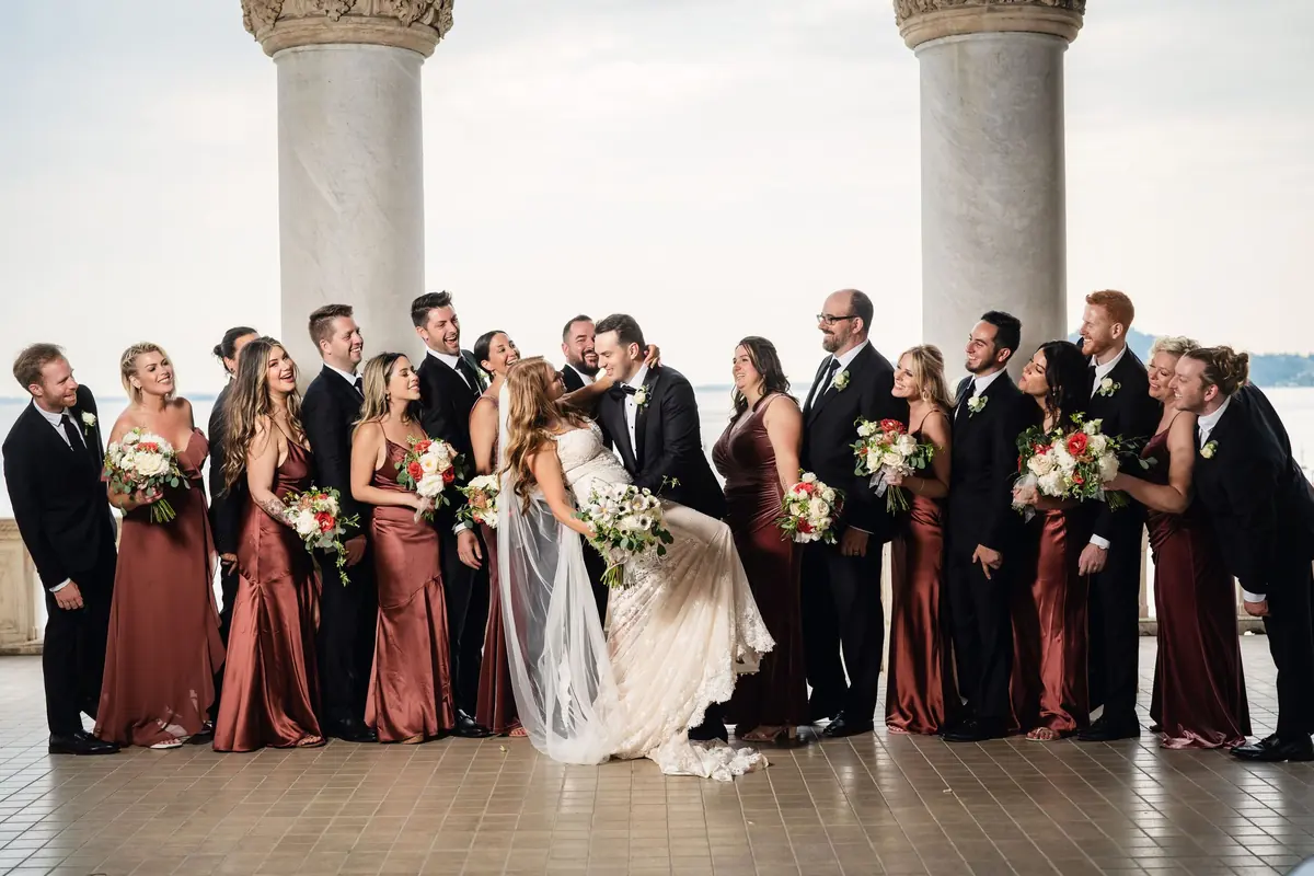 The wedding party laughing together on the terrace