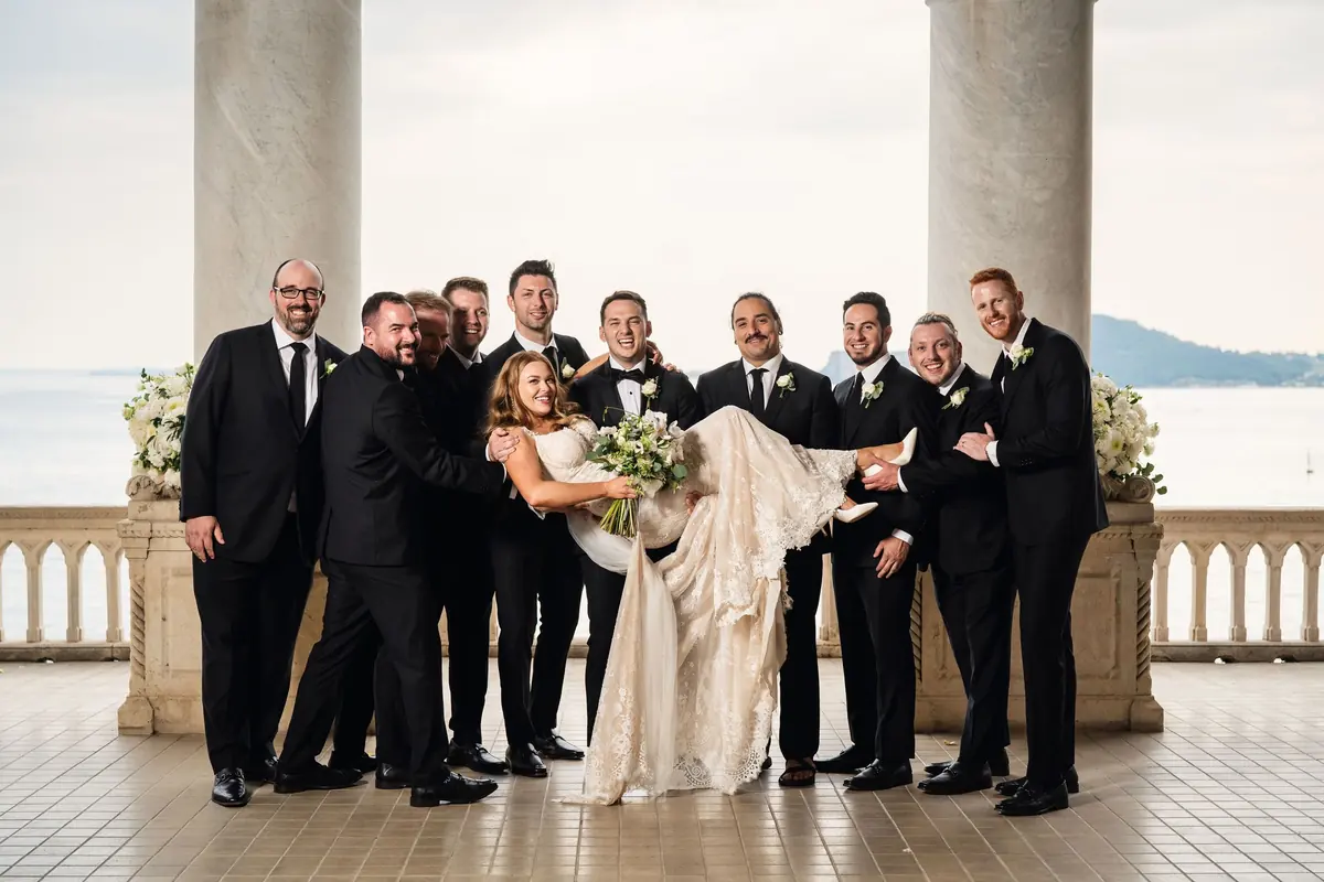 The groomsmen holding Sara up between them