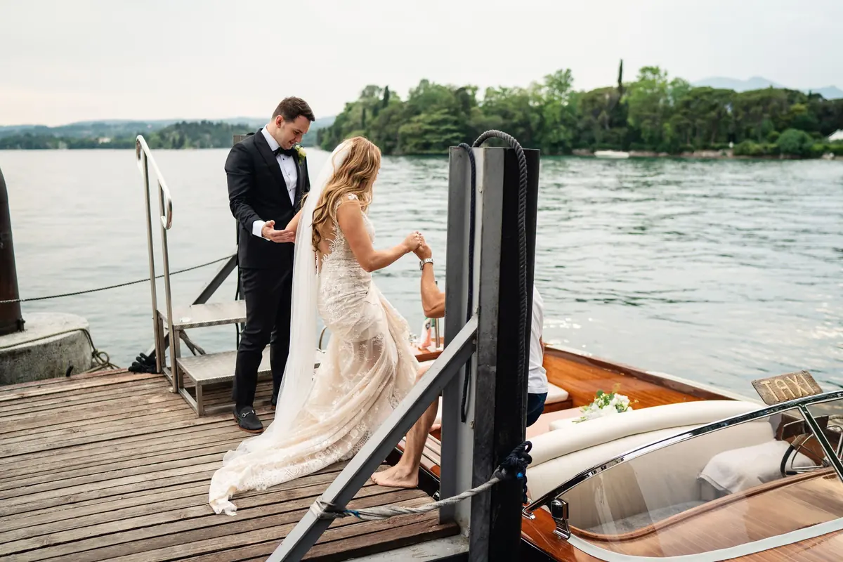 Drew helping Sara aboard the Riva boat at the jetty