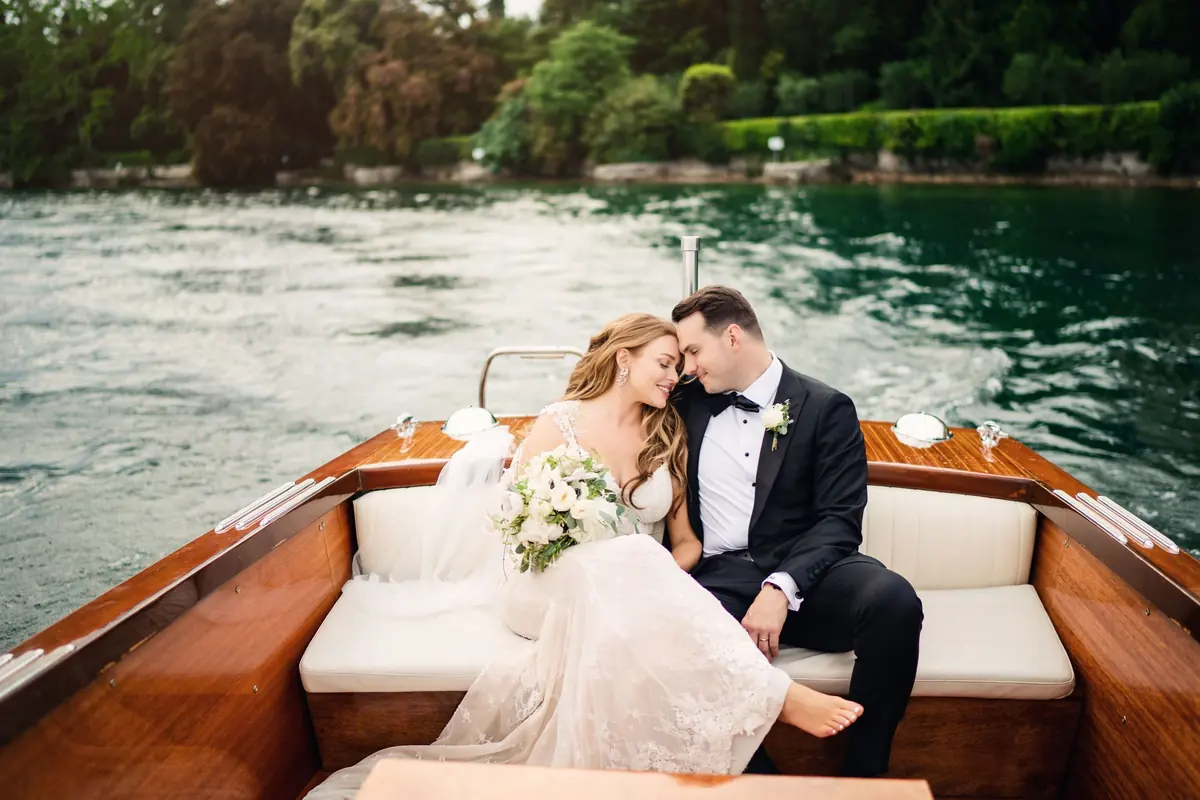 Bride and groom sitting together at the back of the Riva boat