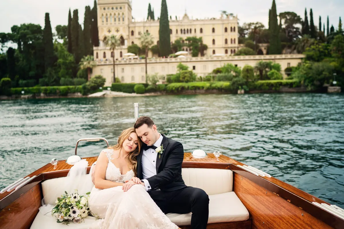 Sara and Drew in the Riva boat with the island villa behind