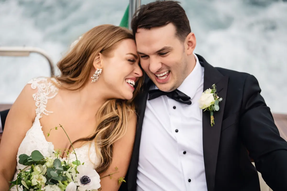 Bride and groom laughing on the Riva boat