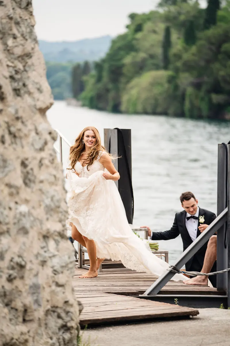 Sara stepping onto the jetty as Drew waits in the boat