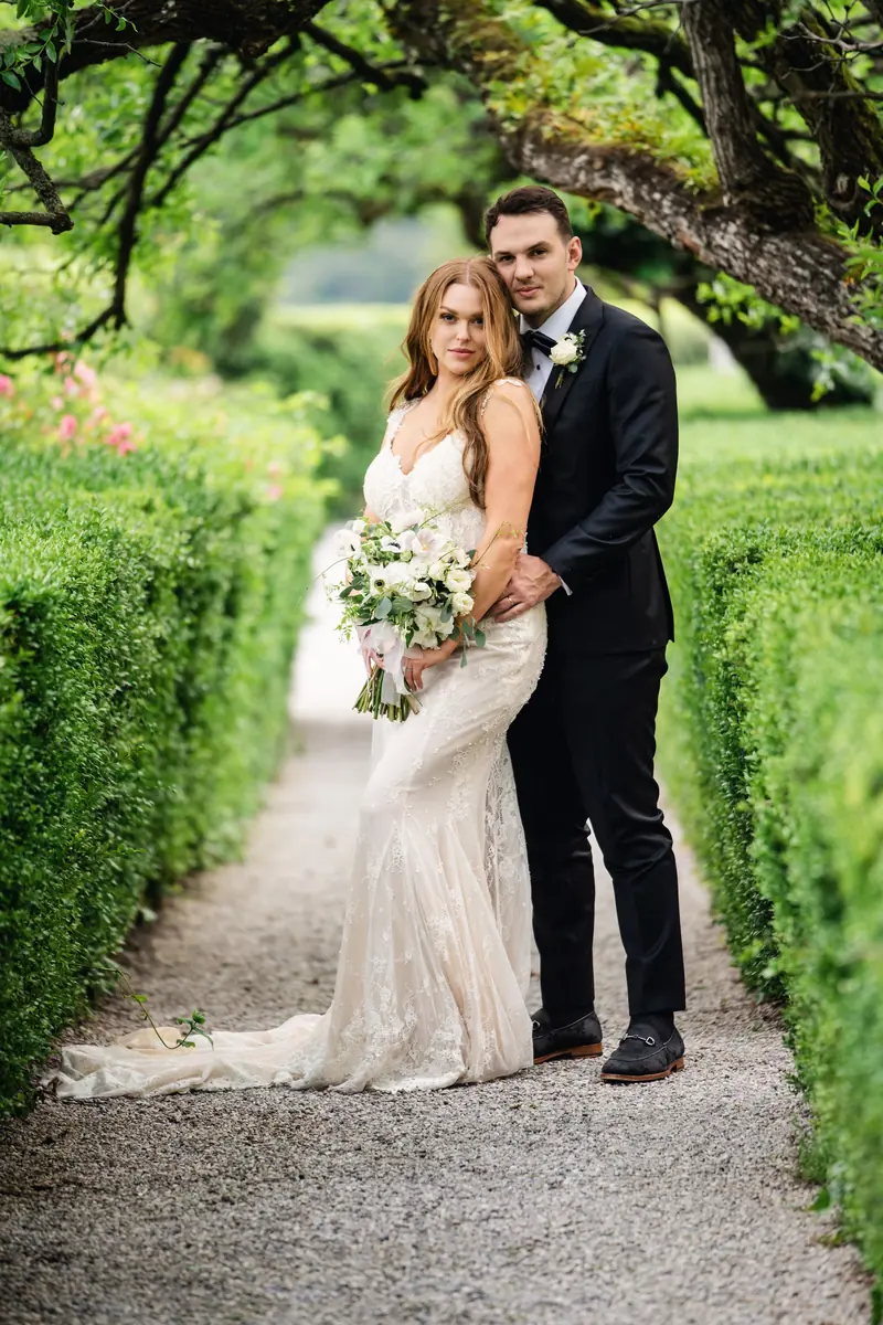 Bride and groom along the hedge-lined path on Isola del Garda