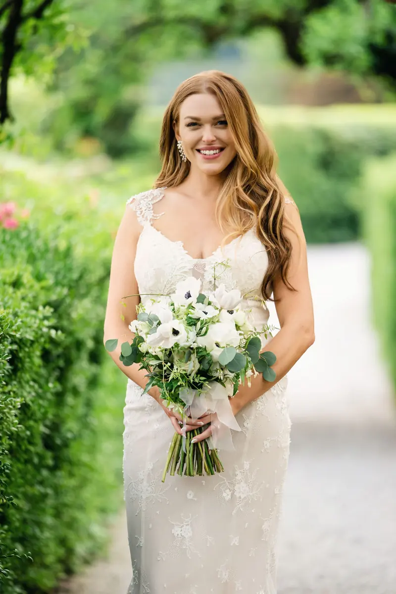 Bride holding her bouquet on the garden path