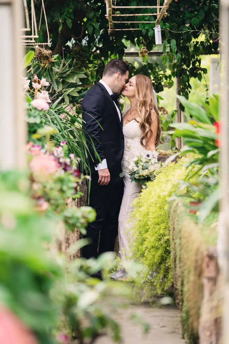 Sara and Drew kissing among the flowers in the gardens