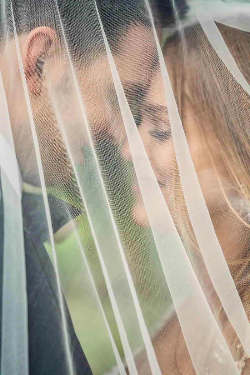 Sara and Drew close together behind her veil