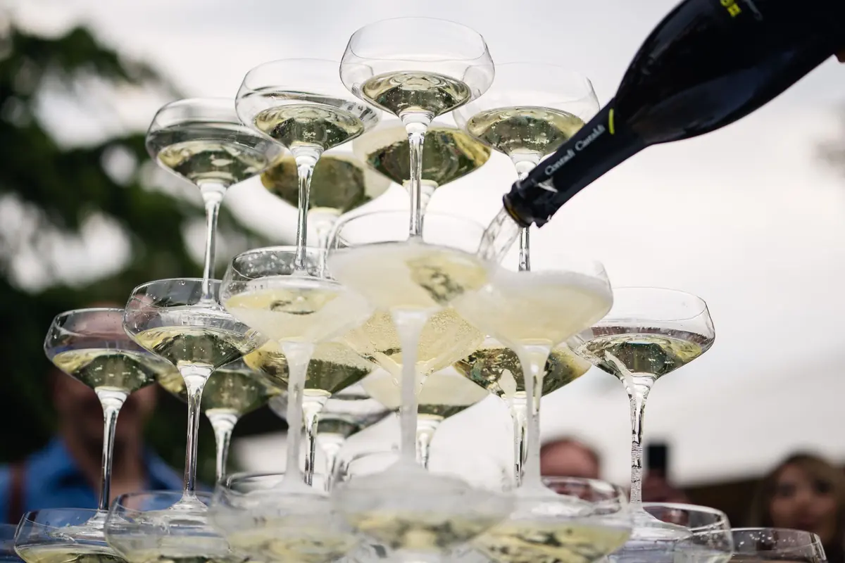 Champagne being poured into a tower of coupes