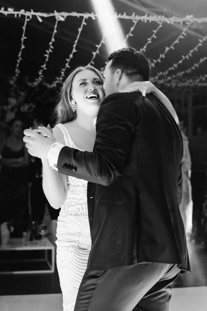 Black and white photo of the couple laughing on the dance floor