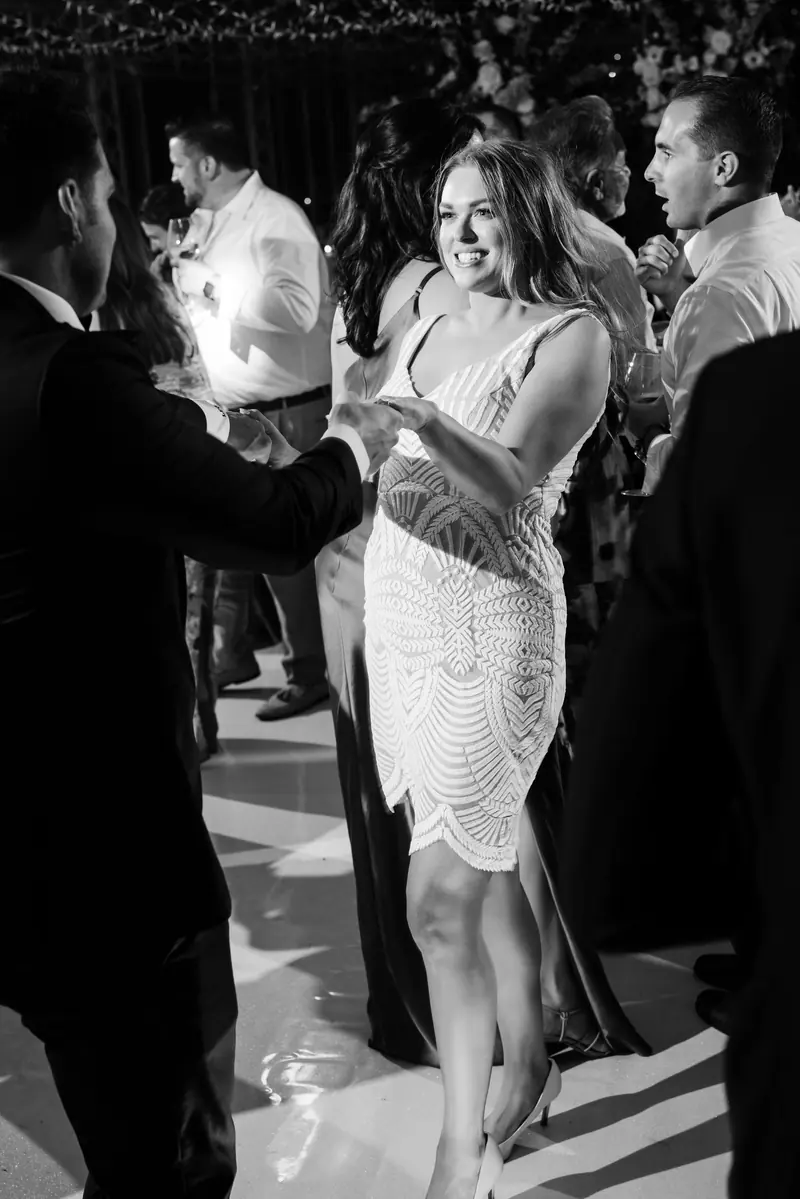 Black and white photo of the bride dancing with guests
