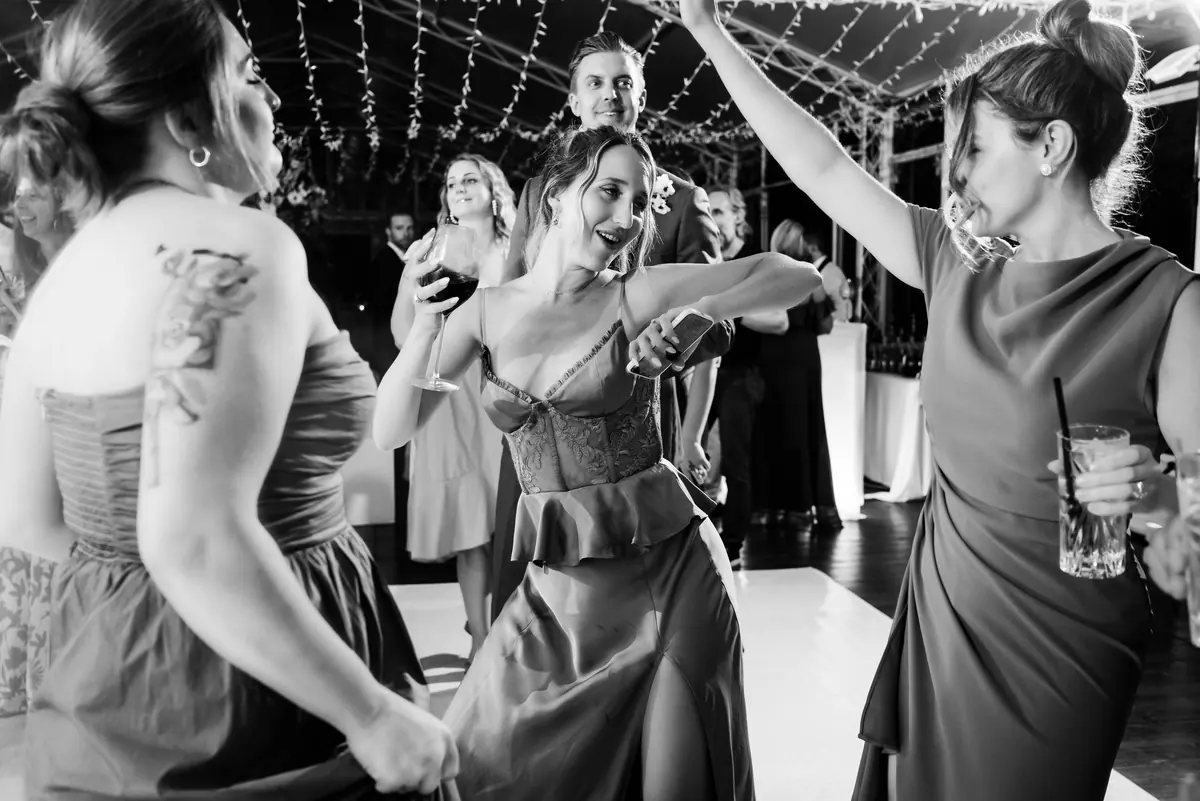 Guests dancing in the marquee, in black and white