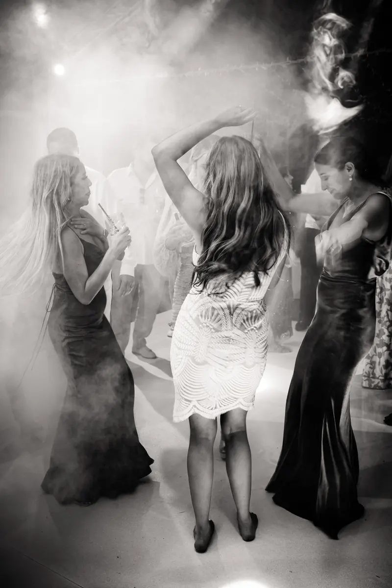 Black and white photo of the bride dancing in the haze