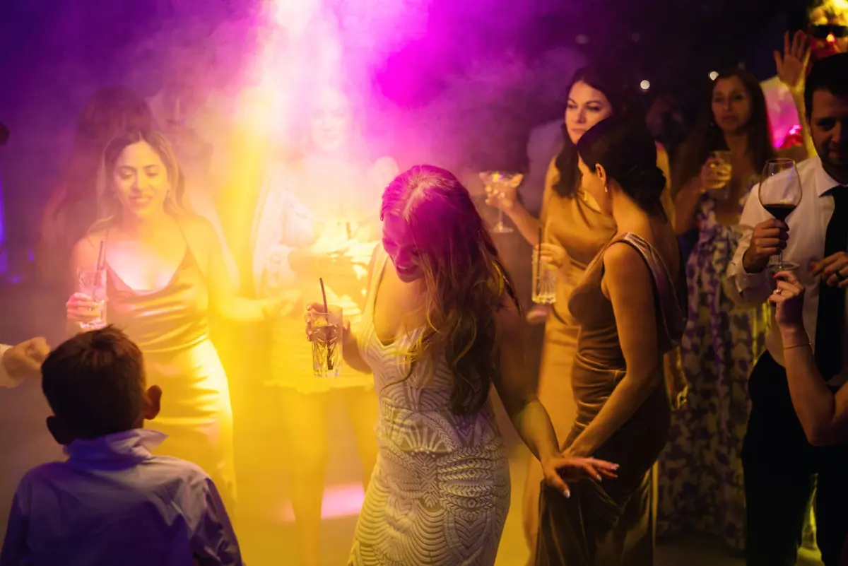 Guests dancing in pink and gold light