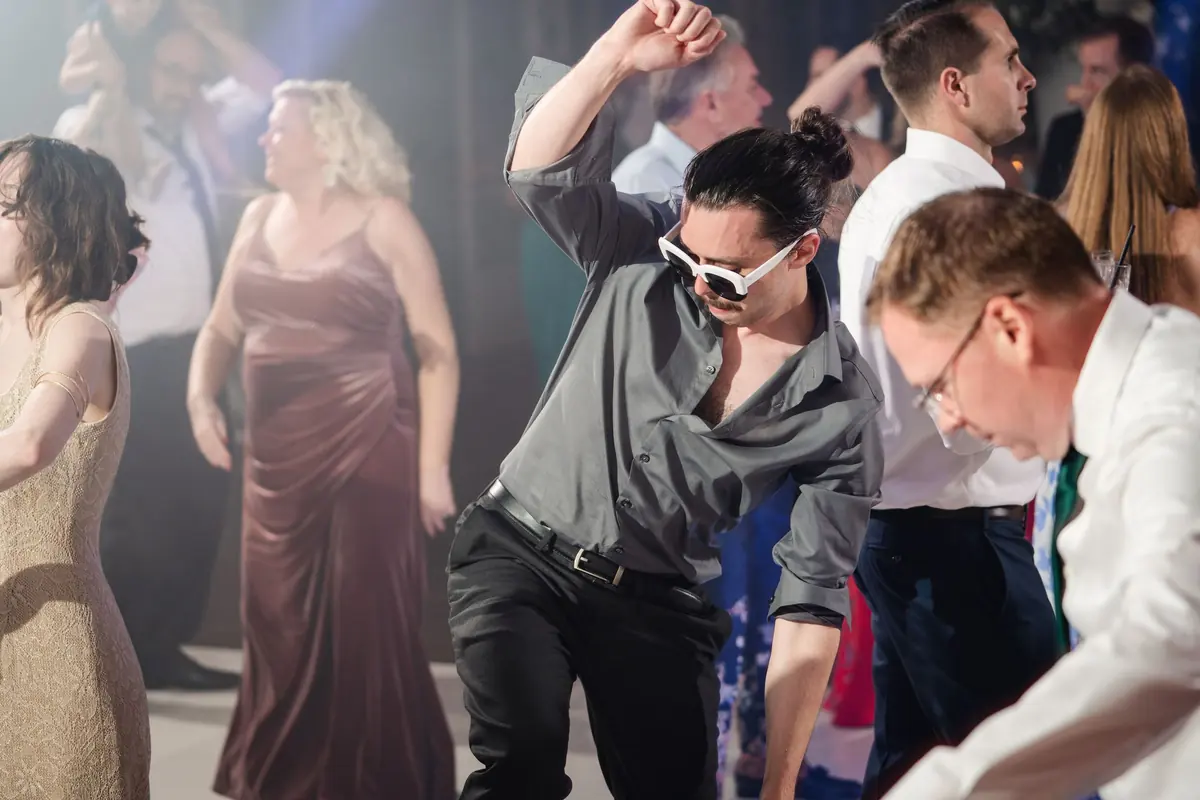 Guests dancing, one in sunglasses