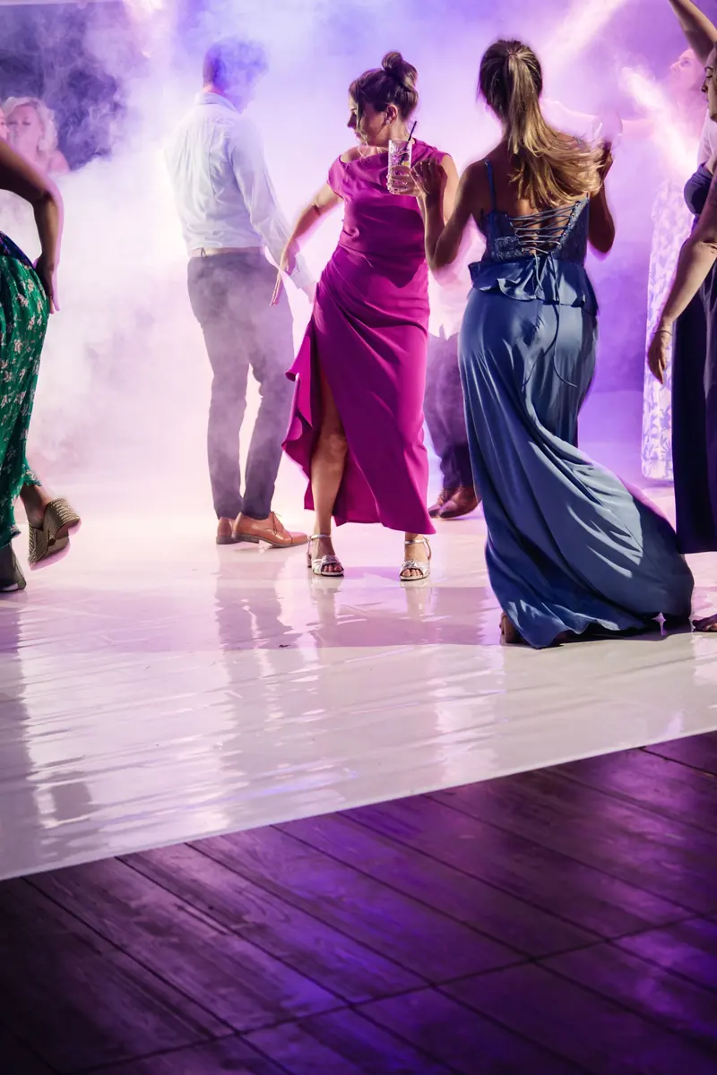 Guests dancing on the white floor in the haze